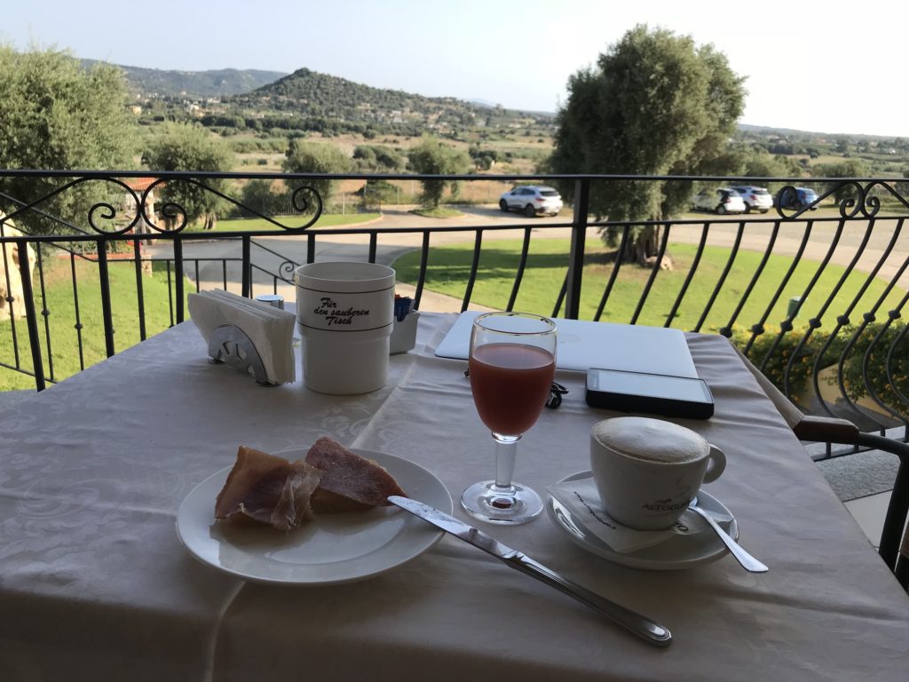 Frühstück auf Terasse mit Capuccino, Orangensaft, Schinken und Salami im Hotel S'Olia